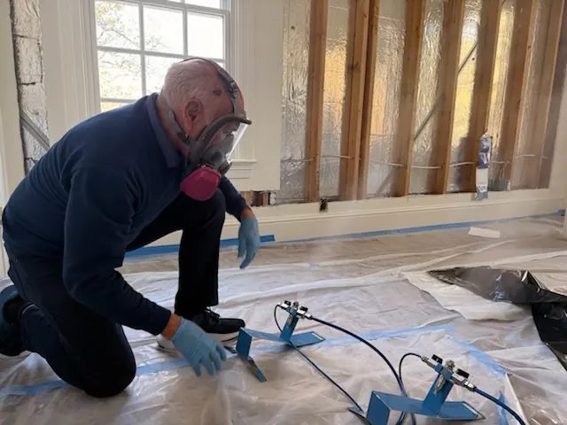 A restoration technician setting drying equipment in a Denver home stripped to the studs